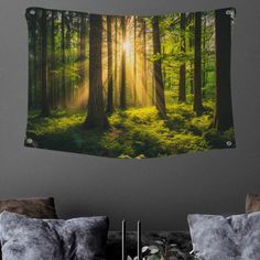 the sun shines through the trees in this forest scene wall hanging on a gray wall