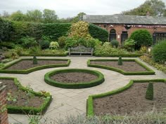 a garden with many different types of plants and shrubs in the center, surrounded by hedges