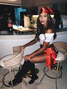 a woman sitting on top of a chair next to a table with a red bow