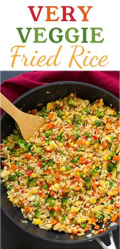 very veggie fried rice in a skillet with a wooden spoon on the side