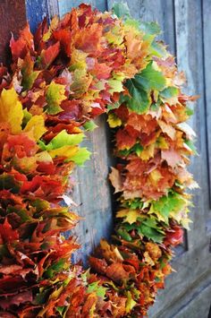 a wreath made out of autumn leaves on a door