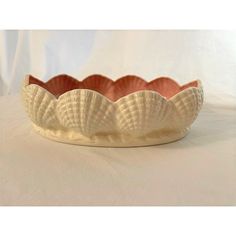 a bowl that is sitting on top of a white tablecloth with an intricate design in the center