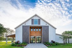 a large white barn with wooden doors and windows