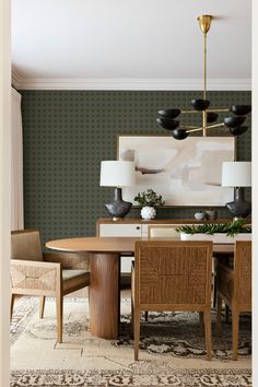 an elegant dining room with green walls and wood furniture, including a round table surrounded by chairs