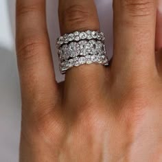 a woman's hand with two wedding rings on her left and the middle finger