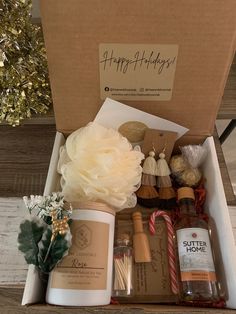 an open gift box filled with personal care items, including handmade soaps and candles