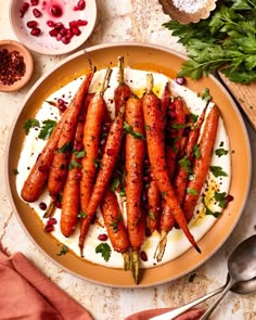 carrots on a plate with yogurt and parsley garnishes