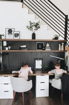 two people sitting at a desk in an office