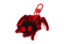 a red and black spider key chain on a white background