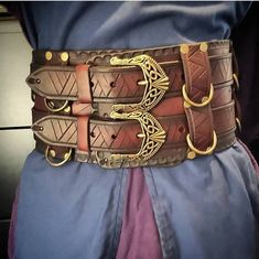 Elevate your Viking, Cosplay, or Larp costume with our 5" inch wide leather belt, meticulously crafted with a Celtic theme. Black or Brown available.  **Exquisite Craftsmanship - Hand-tooled and stamped from 8oz leather. - Dyed to perfection, adorned with rivets, D rings, and 2 sturdy celtic belt and buckles. **Versatile and Customizable - Two adjustable top belts for centering the buckle or wearing alone. - Eight D rings for accessories like sword frogs, mugs, pouch or skirts. (accessories not included) **Ready to Craft Made to order, typically delivered within 1-2 weeks. **Unleash Your Imagination Perfect for Vikings, Cosplay, or Larp, our Deluxe Design Leather Belt adds an authentic finishing touch to your costume. Festival Belts, Viking Hall, Medieval Accessories, Celtic Warrior, Kung Lao, Viking Belt, Viking Armor, Costume Armour, Medieval Belt