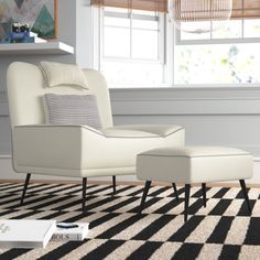 a white chair and ottoman in a living room with black and white checkered carpet