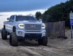 a white truck driving down a dirt road