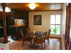 a dining room table with two chairs and a bench in front of the mirror on the wall