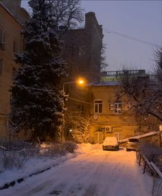 a snow covered street with cars parked on it