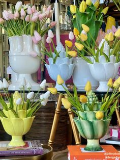 several vases with flowers in them sitting on top of a table next to each other