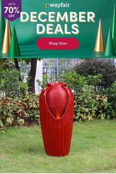 a red vase sitting on top of a lush green field