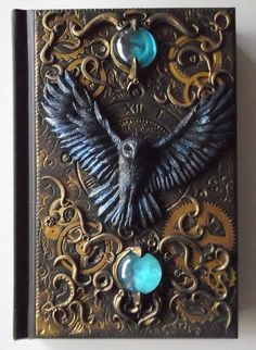 an intricately decorated book with a bird and gears on it's front cover