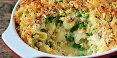 a casserole dish with peas, cheese and bread crumbs on top