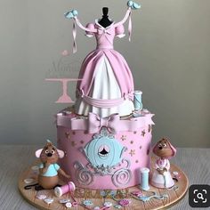 a pink and white cake with a dress on top