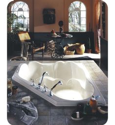 a large white bath tub sitting on top of a tiled floor next to two windows