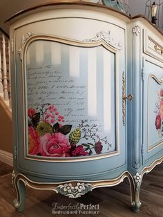 an ornate painted armoire with flowers and writing on the front door is shown in this image