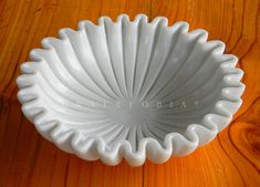 a white bowl sitting on top of a wooden table