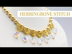 the herringbone stitch necklace is made with gold beads and swarong crystal drops