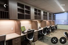 an office with desks and chairs in front of a large window