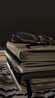 a stack of books with glasses on top