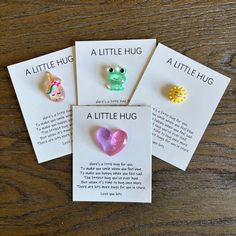 four little hug earrings on top of a card with the words, a little hug