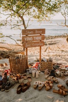 there is a sign that says shoes here you're there on the beach with many pairs of sandals