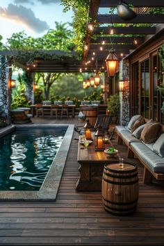 an outdoor dining area next to a pool with lights hanging from the ceiling and chairs around it