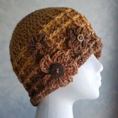 a crocheted hat with buttons on the front and side, sitting on a mannequin head