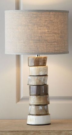 a lamp that is sitting on top of a table next to a wall and window