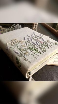 an old book with embroidered flowers on it