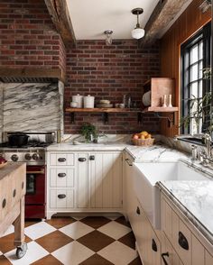 a kitchen with brick walls and white cabinets