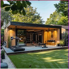 a home gym with exercise equipment in the back yard, surrounded by lush green grass