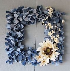 a wreath made out of blue and white paper with a flower on the front side