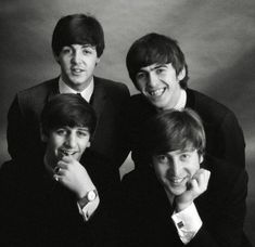 the beatles posing for a black and white photo