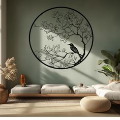 a bird is sitting on a tree branch in a circular metal wall art piece,