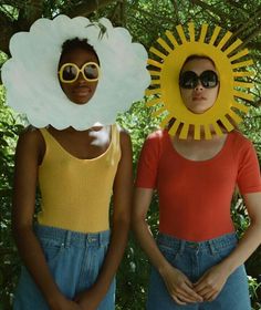 two women wearing sunflowers and sunglasses standing next to each other