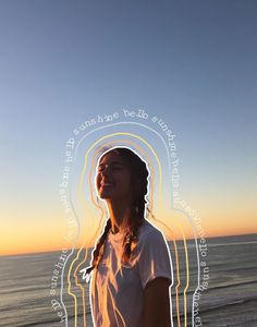 a woman standing on top of a beach next to the ocean with her eyes closed