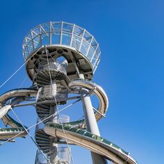 a very tall metal structure with a spiral staircase going up it's side against a blue sky