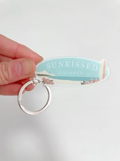 someone is holding up a keychain that says sunkied coconut on it and has a ring attached to it