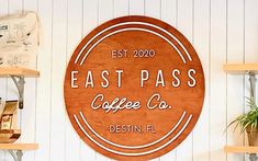 a sign that says east pass coffee co in front of shelves with plants and other items