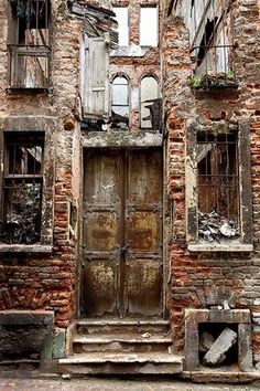 an old brick building with two doors and windows