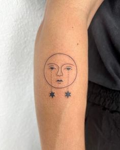 a woman's arm with a small sun and stars tattoo on the left forearm