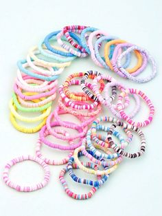 many different colored bracelets on a white surface