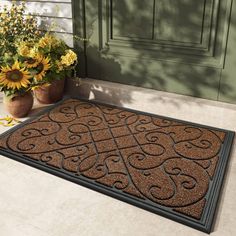 a brown door mat sitting on top of a floor next to flowers and potted plants