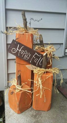 three pumpkins stacked on top of each other in front of a house with the word happy written on them